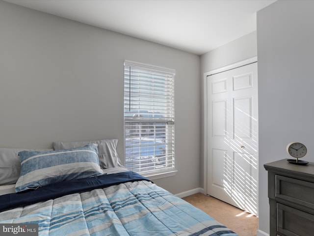 carpeted bedroom with a closet and multiple windows