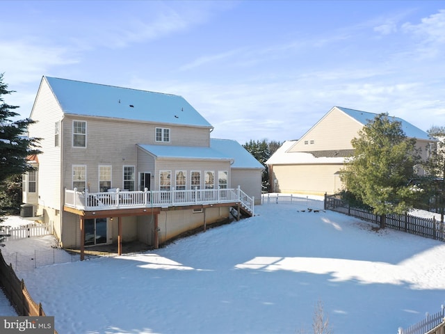 snow covered rear of property with central air condition unit and a deck