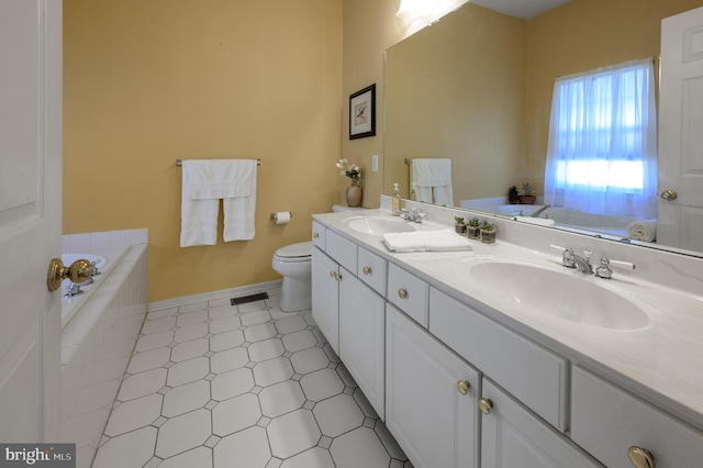 bathroom with tile patterned flooring, tiled bath, vanity, and toilet