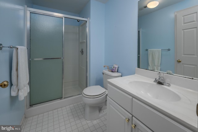 bathroom with toilet, tile patterned flooring, a shower with door, and vanity