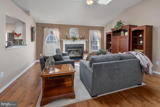 living room with lofted ceiling, wood-type flooring, and ceiling fan