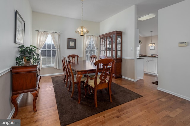 dining area with hardwood / wood-style flooring and a notable chandelier