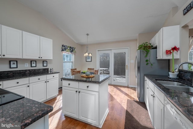 kitchen featuring white cabinetry, dishwasher, hanging light fixtures, and sink