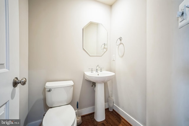 bathroom with hardwood / wood-style flooring and toilet