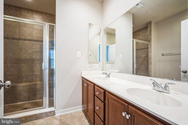 bathroom featuring vanity, a shower with shower door, and tile patterned flooring