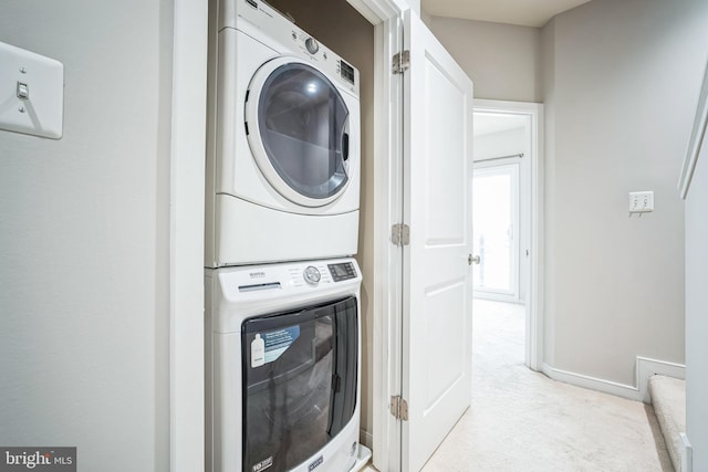 washroom featuring light carpet and stacked washer / drying machine