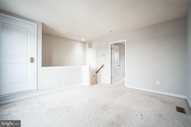 spare room featuring light colored carpet