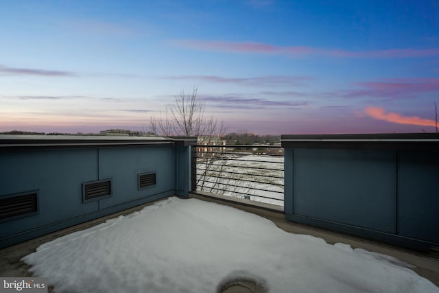 snow covered patio featuring a balcony