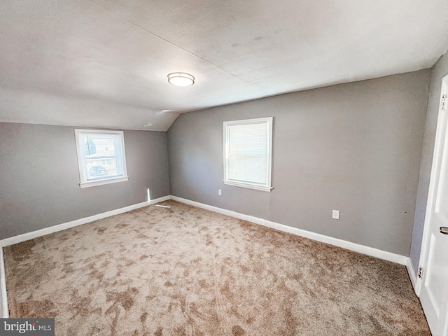 bonus room with carpet flooring and vaulted ceiling