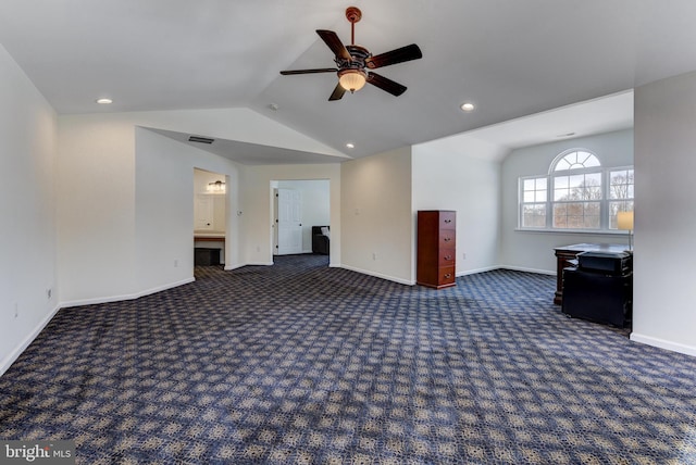 unfurnished living room with ceiling fan, lofted ceiling, and dark carpet