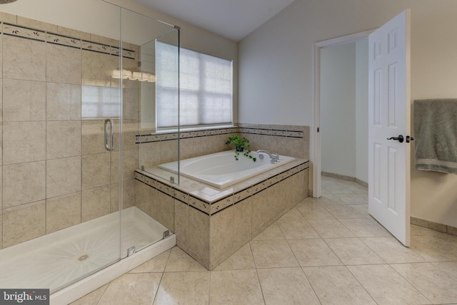 bathroom featuring tile patterned flooring, vaulted ceiling, and independent shower and bath