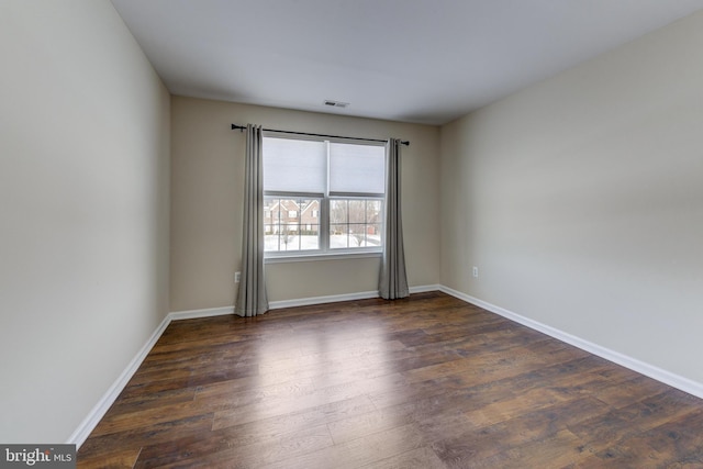 spare room featuring dark hardwood / wood-style flooring