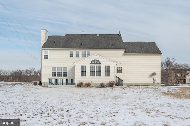 snow covered house with central air condition unit