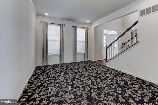 empty room with crown molding and carpet flooring