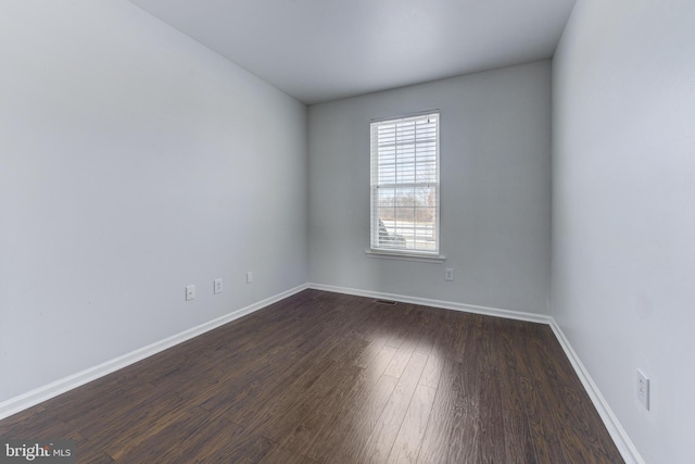 unfurnished room with dark wood-type flooring