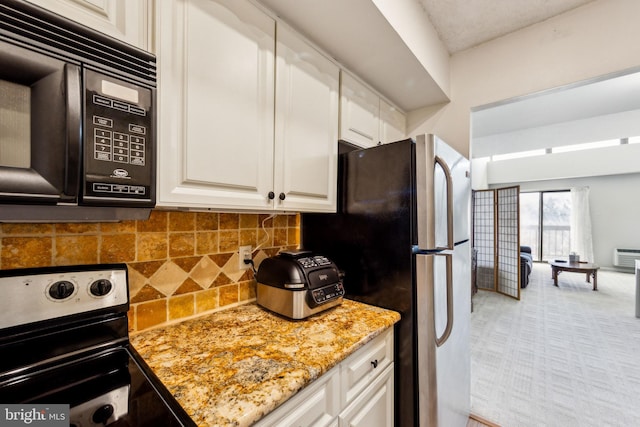 kitchen with appliances with stainless steel finishes, white cabinetry, tasteful backsplash, and light stone countertops