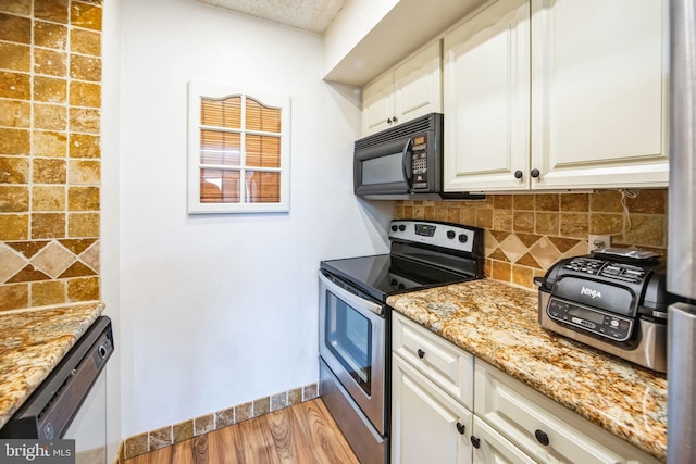 kitchen with hardwood / wood-style floors, stainless steel appliances, tasteful backsplash, white cabinets, and light stone counters