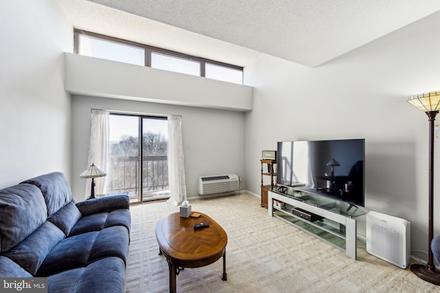 carpeted living room with a high ceiling, a textured ceiling, and a wall mounted air conditioner