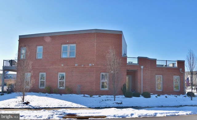 snow covered property featuring a balcony