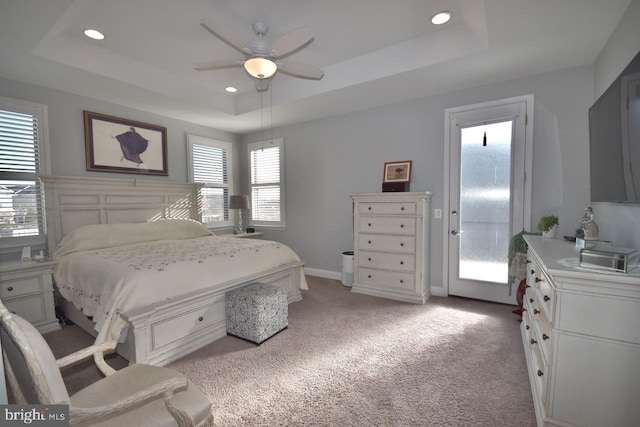 bedroom featuring ceiling fan, access to outside, a raised ceiling, and light colored carpet