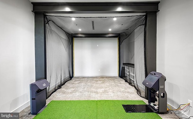 carpeted home theater room with golf simulator