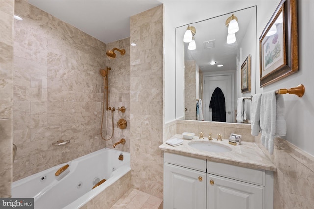 bathroom featuring tile walls, vanity, and tiled shower / bath