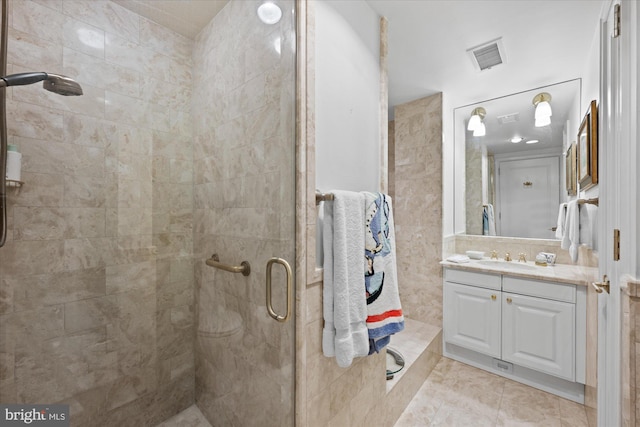 bathroom featuring vanity, tile patterned flooring, and a shower with shower door