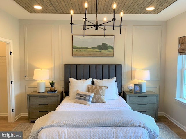 bedroom with light hardwood / wood-style floors and a chandelier