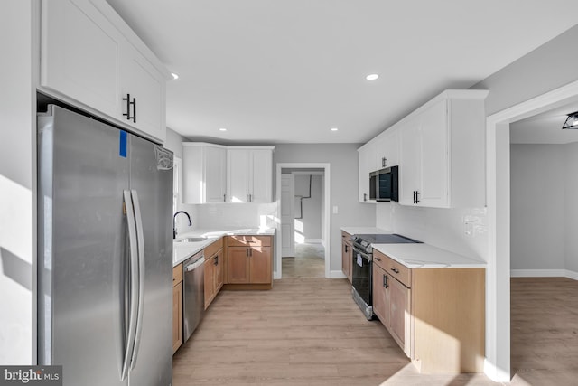 kitchen with tasteful backsplash, sink, white cabinets, and appliances with stainless steel finishes