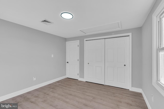 unfurnished bedroom with light hardwood / wood-style floors and a closet