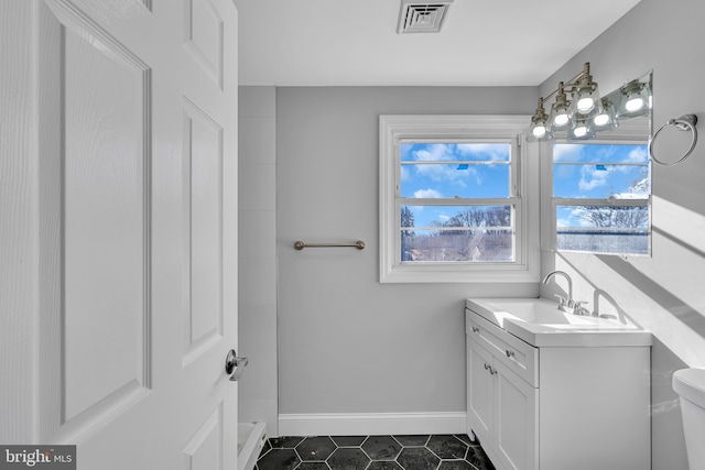 bathroom featuring tile patterned flooring, vanity, and toilet