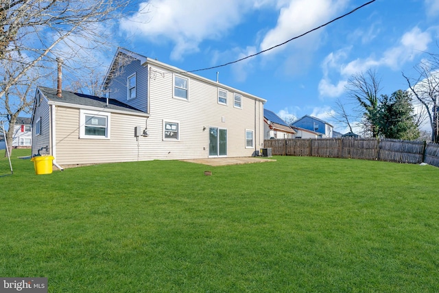 back of house with central AC, a patio, and a lawn