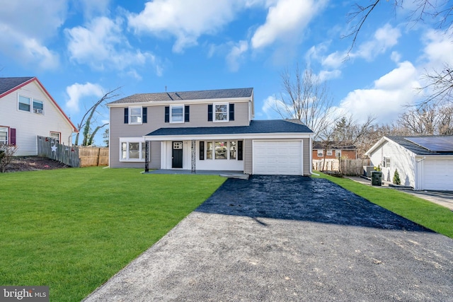 front of property featuring cooling unit, a garage, and a front lawn