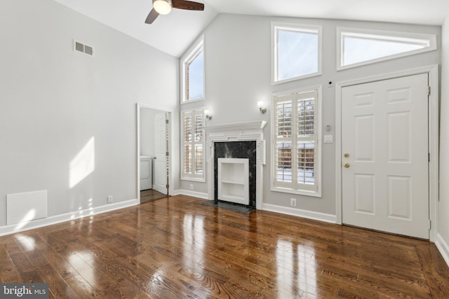 interior space featuring dark wood-type flooring, high vaulted ceiling, ceiling fan, and a fireplace