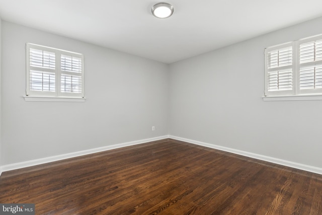 empty room with dark hardwood / wood-style flooring