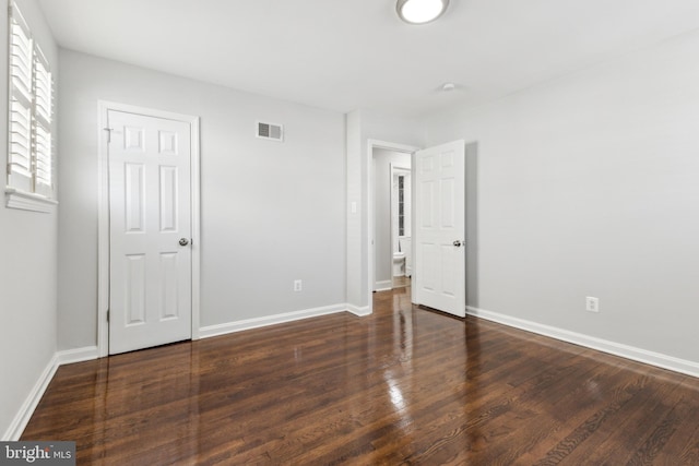 unfurnished bedroom with dark wood-type flooring