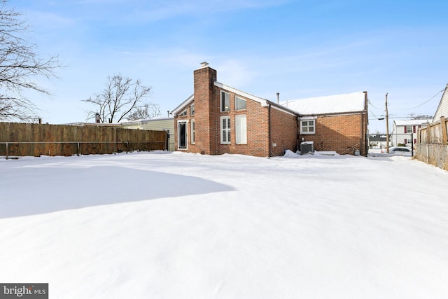 snow covered property with central AC