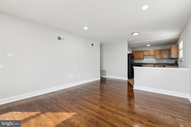 unfurnished living room with dark hardwood / wood-style flooring and sink