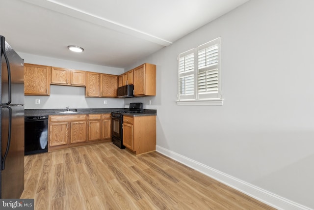 kitchen featuring black appliances, light hardwood / wood-style flooring, and sink