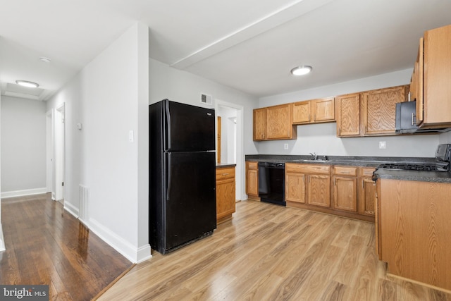 kitchen featuring sink, light hardwood / wood-style floors, and black appliances