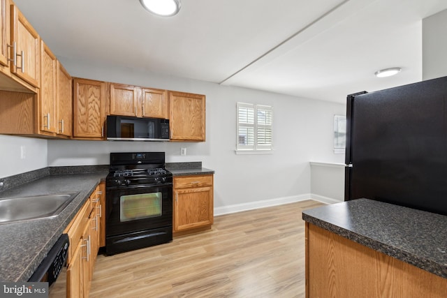 kitchen featuring sink, black appliances, and light hardwood / wood-style flooring