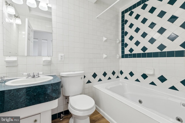 full bathroom with tile walls, toilet, wood-type flooring, vanity, and tiled shower / bath combo