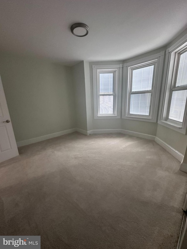 unfurnished room featuring light carpet