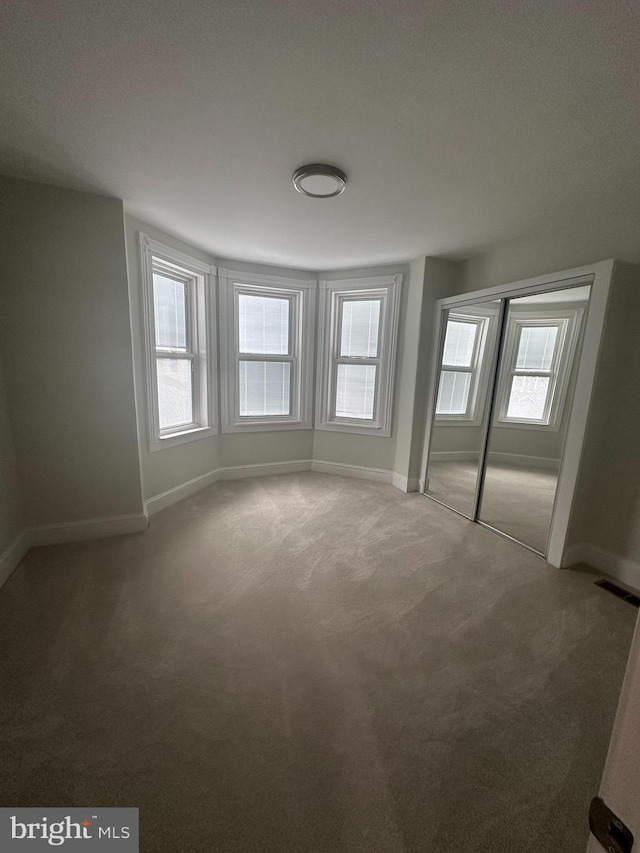 empty room featuring carpet and a healthy amount of sunlight