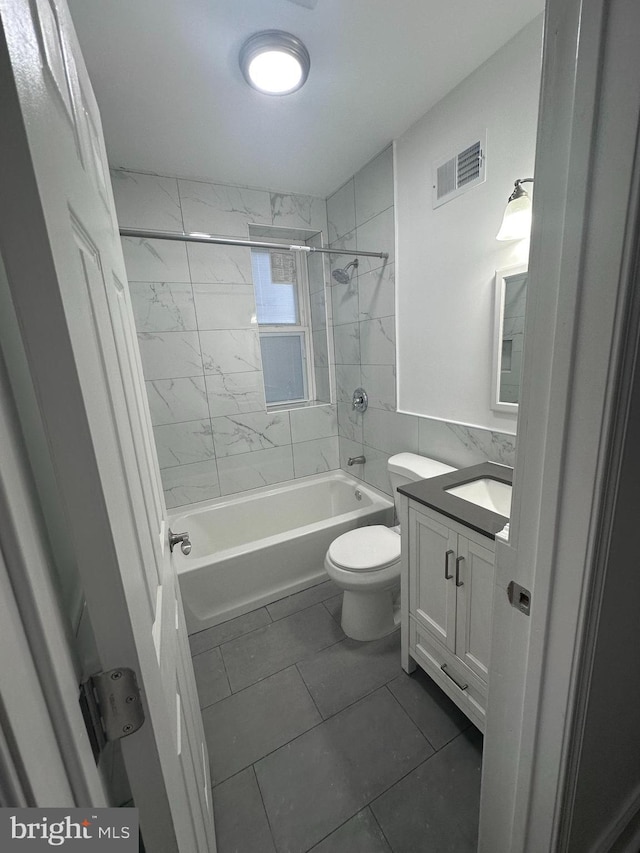 full bathroom featuring toilet, vanity, tile patterned flooring, and tiled shower / bath