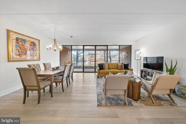 dining room featuring a chandelier, a wall of windows, and light hardwood / wood-style flooring