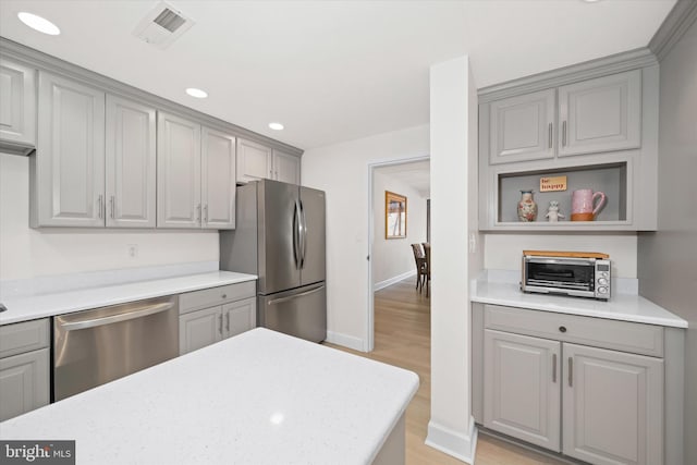 kitchen featuring stainless steel appliances, gray cabinetry, and light hardwood / wood-style floors