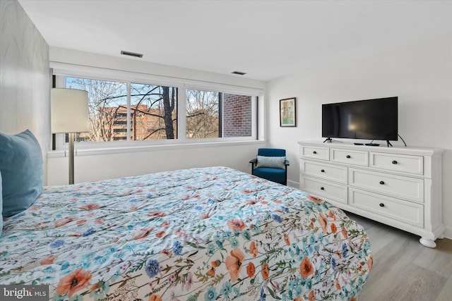 bedroom featuring hardwood / wood-style flooring and multiple windows