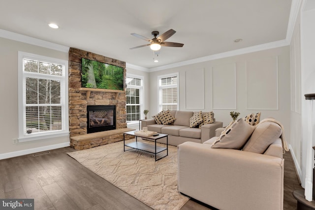 living room with ceiling fan, hardwood / wood-style floors, crown molding, and a fireplace