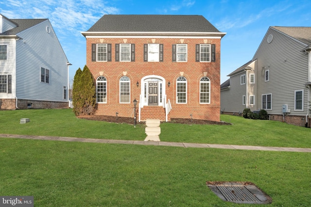 colonial home featuring a front yard